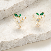 A pair of silver gold plated earrings with green stones, pearls and shell flowers.